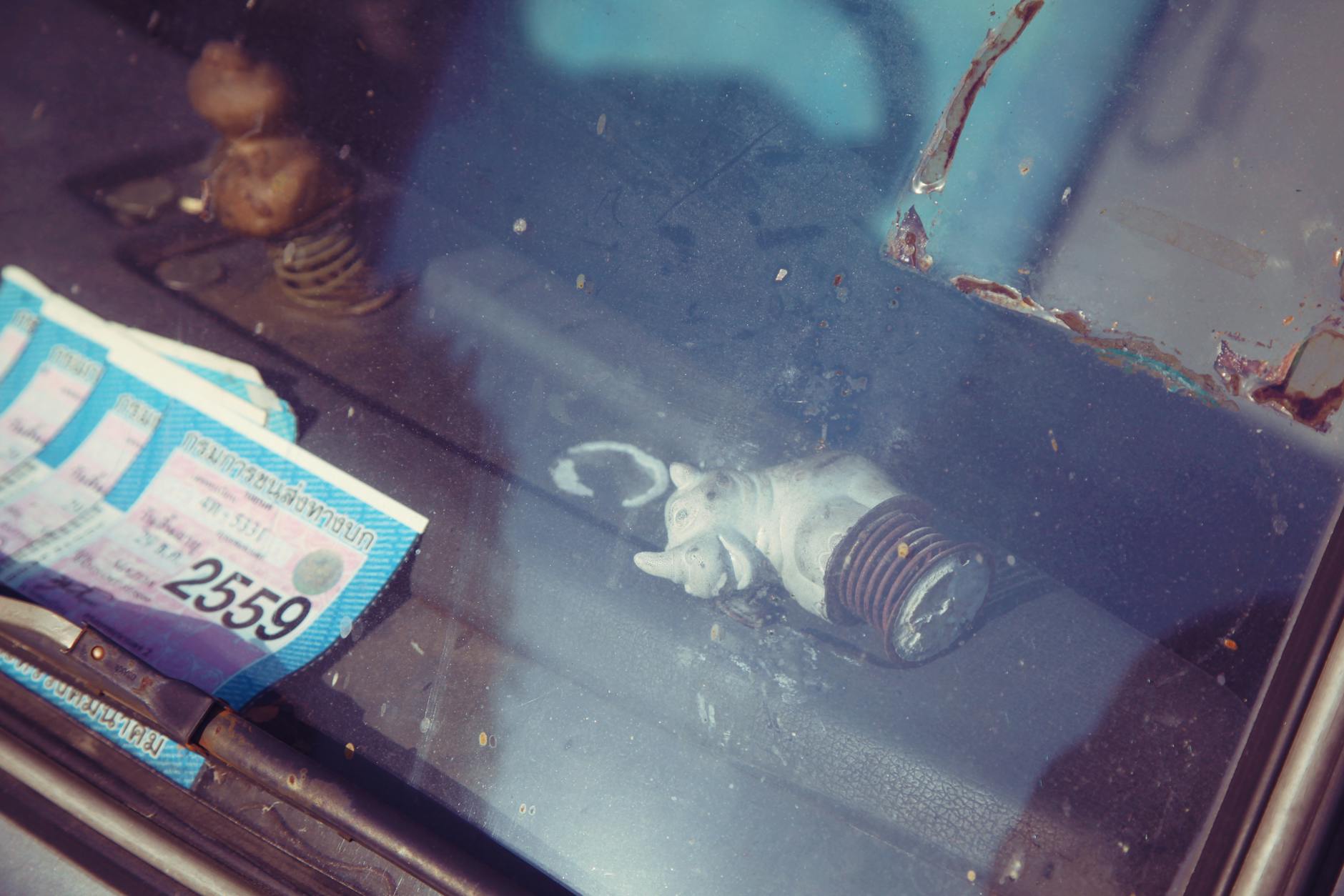 Dokumenty pozwolenia na budowę i figurka nosorożca widziane przez szybę