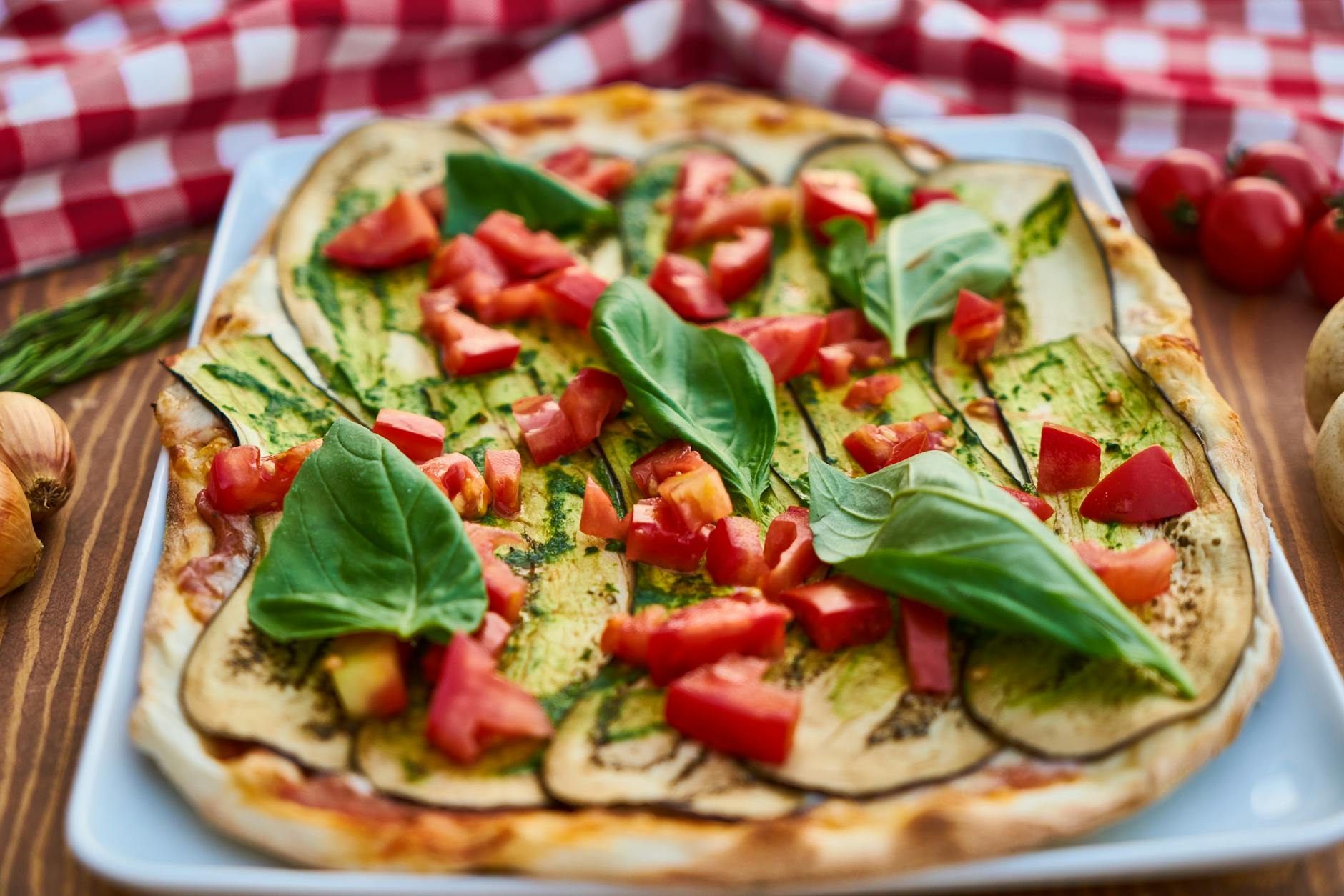 Zbliżenie na włoską pizzę z bakłażanem, bazylią i pomidorami