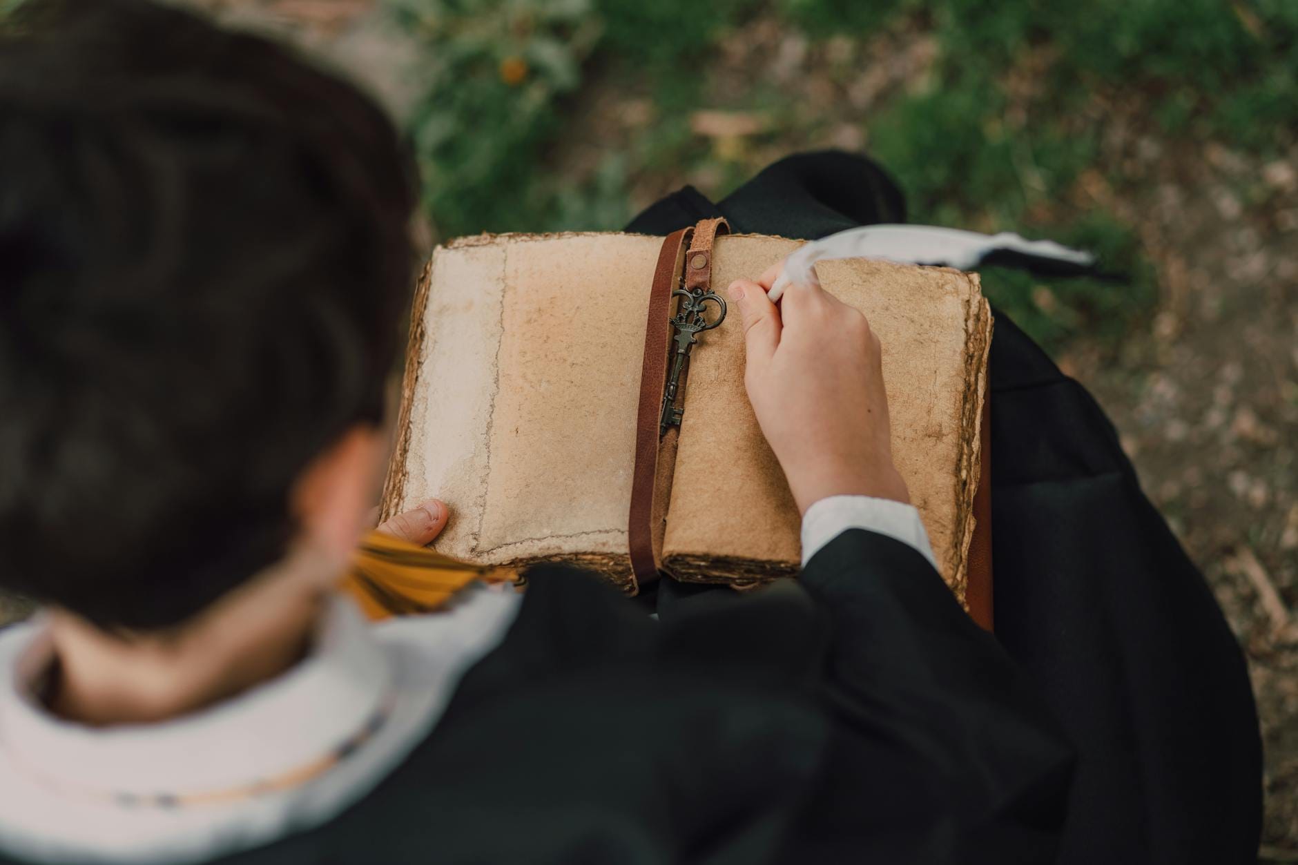 Młoda osoba w szacie trzyma stary tom Księgi Przemian na dworze