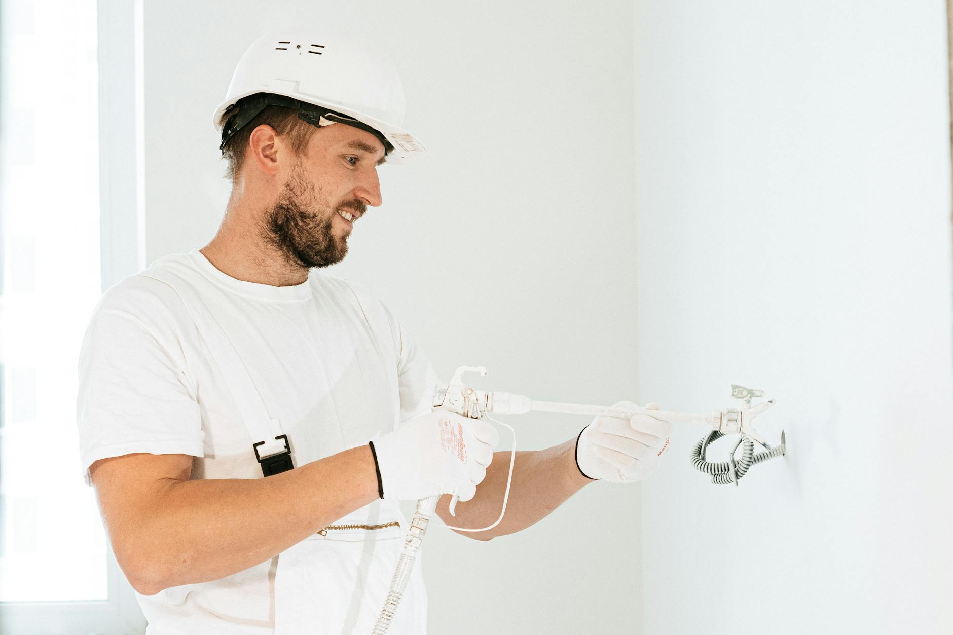 Elektryk w kasku prowadzi instalację elektryczną w nowym budynku