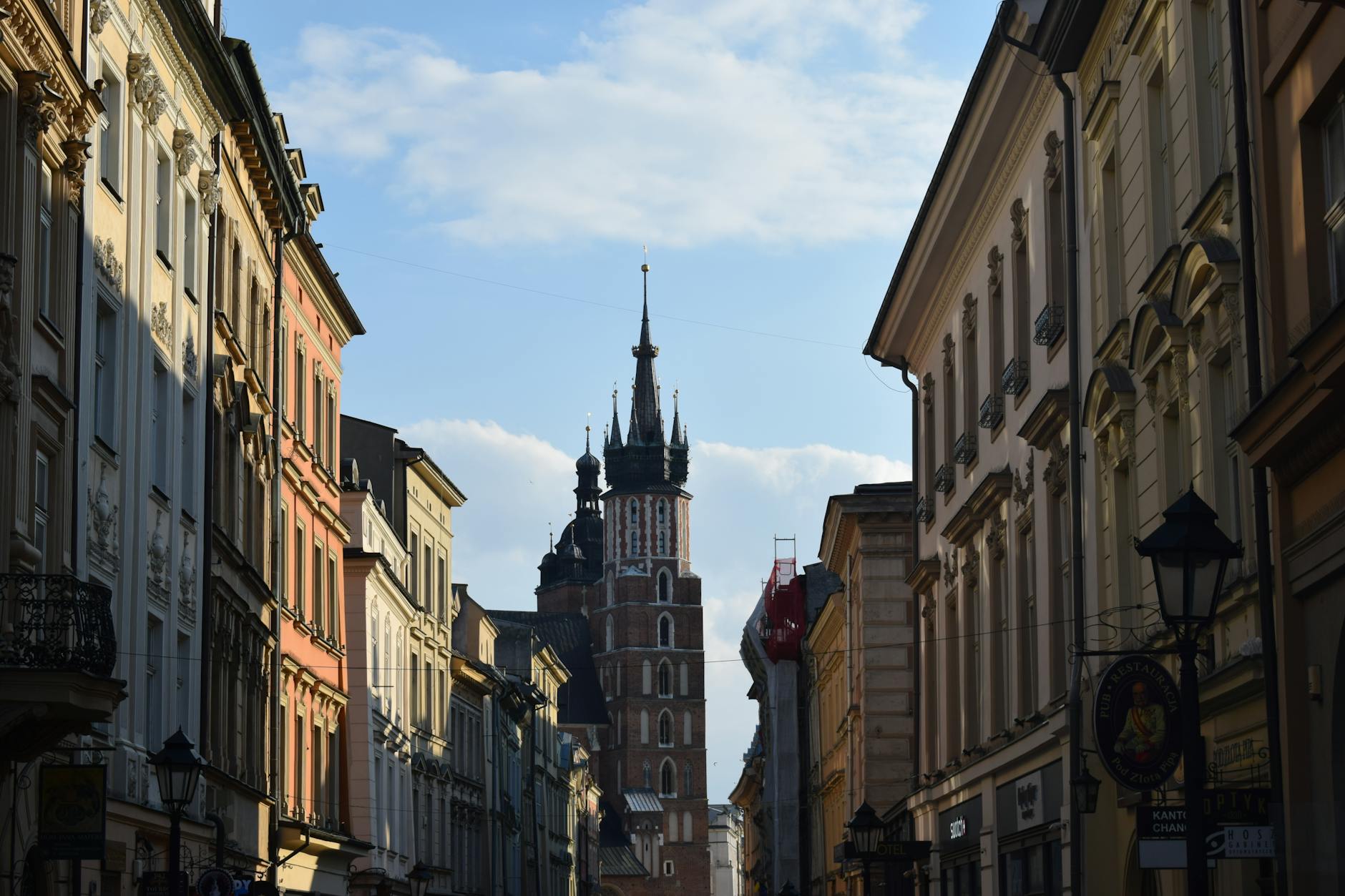 Ulica w Krakowie z widokiem na Bazylikę Mariacką w słoneczny dzień