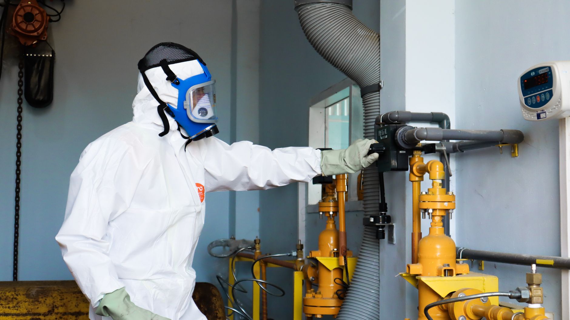 Pracownik w kasku kontroluje instalację gazową w zakładzie