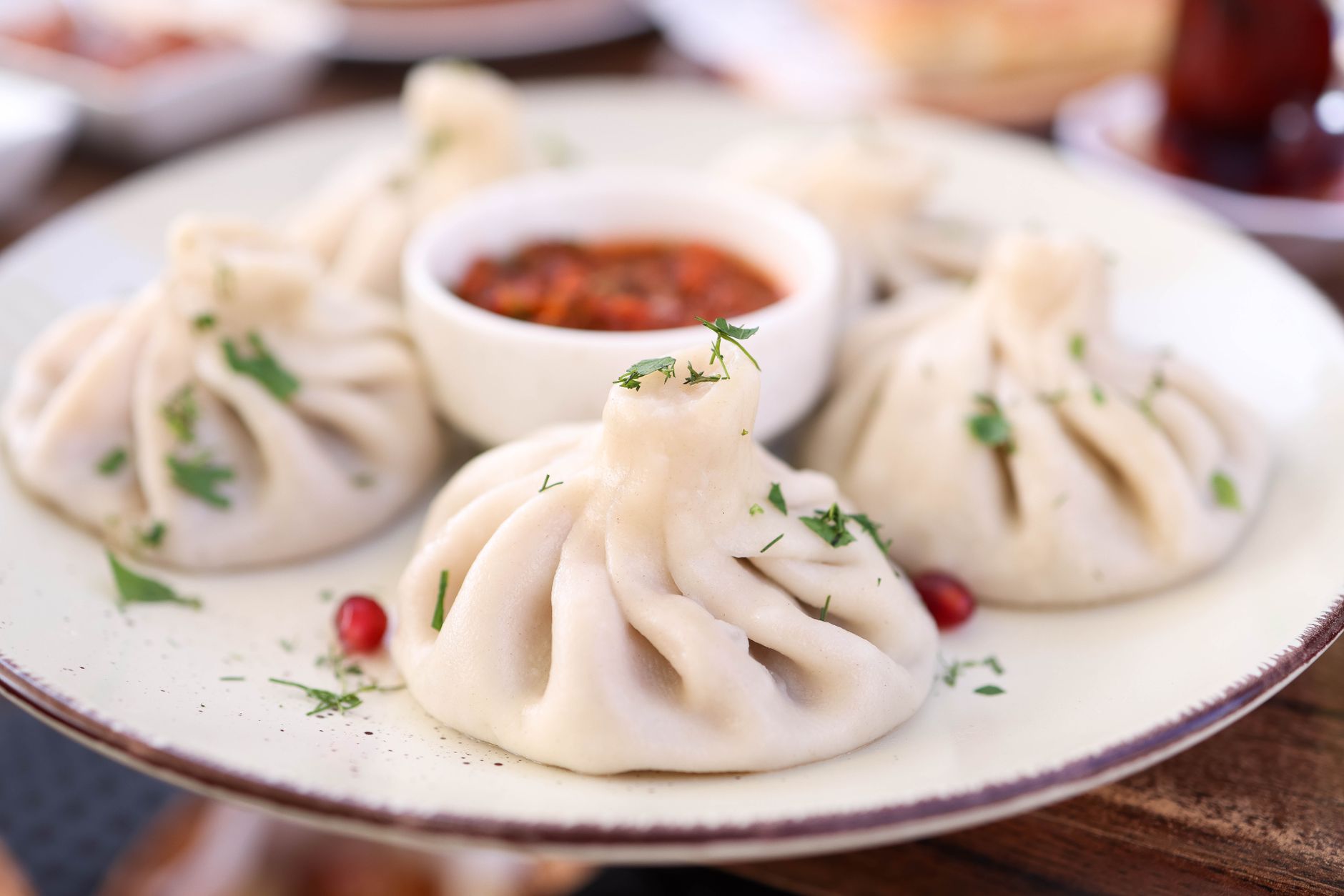 Chinkali na talerzu z pikantnym sosem pomidorowym